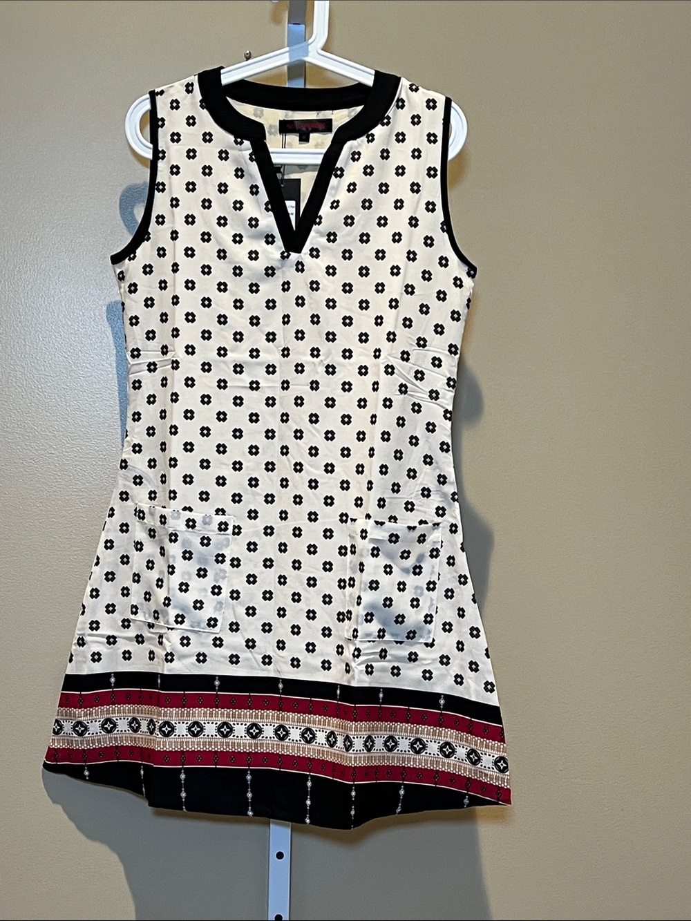 Sleeveless White Floral Mini Dress with Black Trim and Red Hem Accent